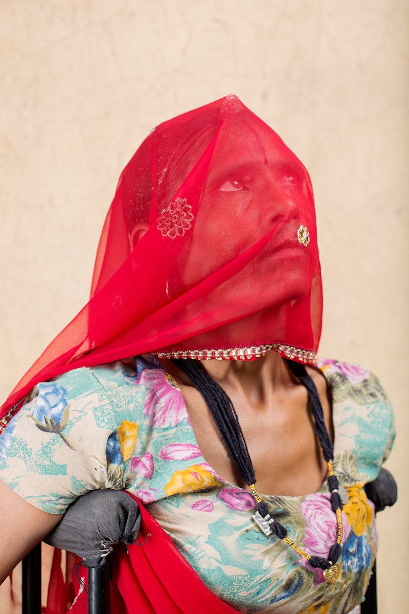 Portrait of Manju with her face covered by a headscarf.