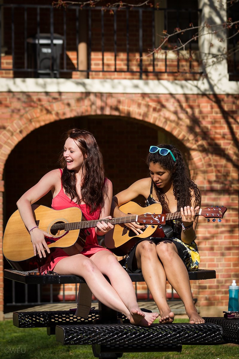 Akeesha Corbin ('15), right, and Charlotte "Charlie" Titcomb ('15) play guitars outside Poteat Residence Hall one spring morning.