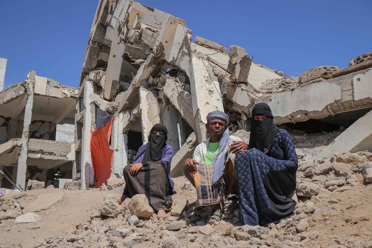 An internally displaced family sits among rubble in Al-Dhale’e Governorate. ©UNOCHA/Mahmoud Fadel-YPN