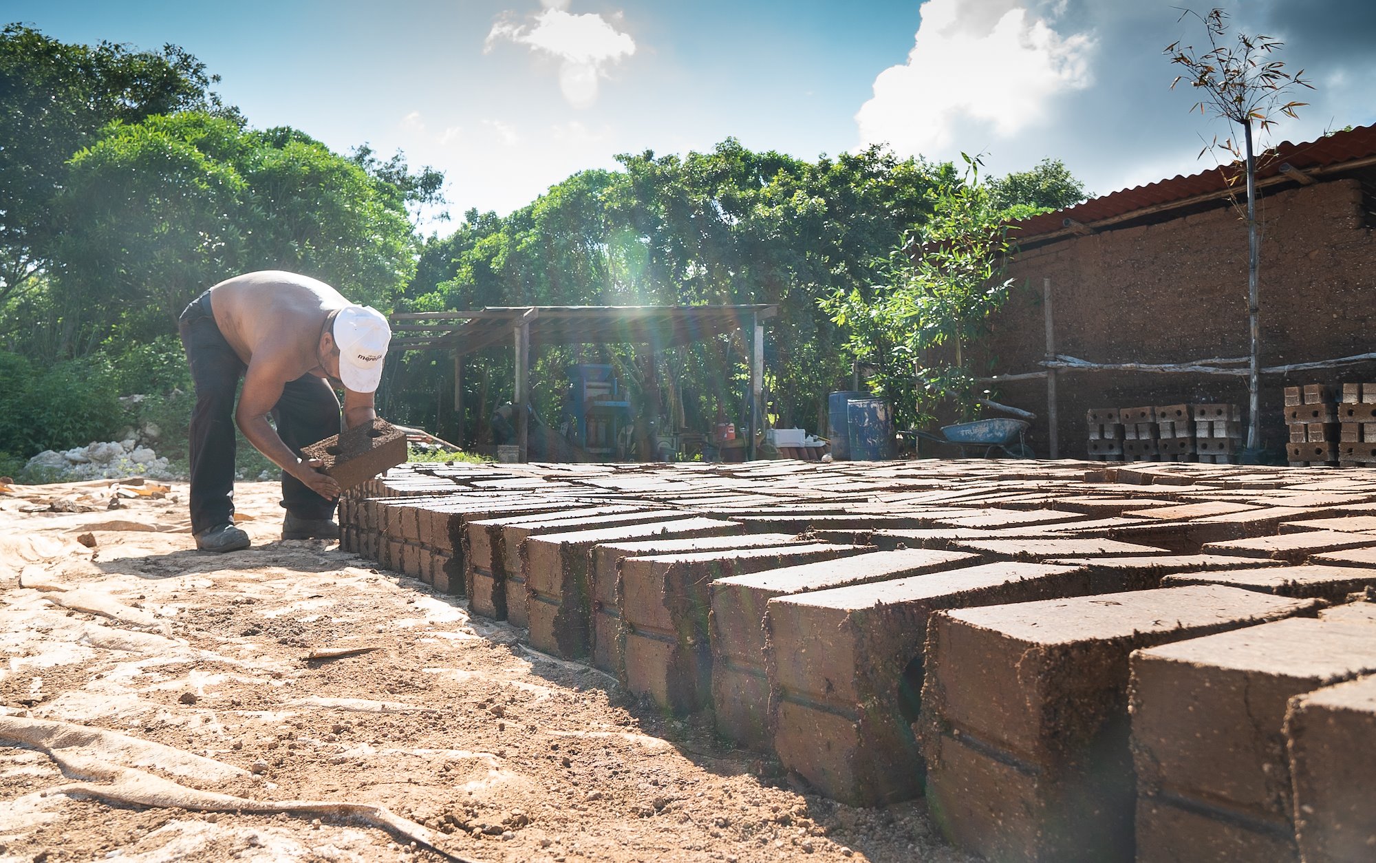 worker placing Sargablocks in hot sun to dry