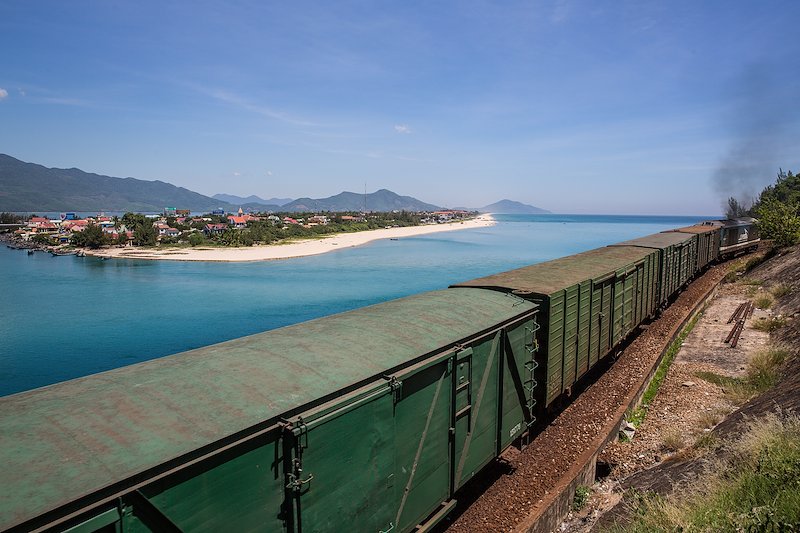 A train on its way to Hoi An travels alongside the road cutting through the mountain pass.