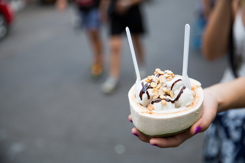 Simple yet delicious. Coconut ice cream, served in a halved coconut and topped with peanuts and chocolate sauce.