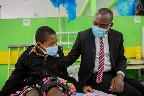 The Spiritual Director spends his time in the ward. Chimwemwe, the Spiritual director , has a chat with a child by his bedside.