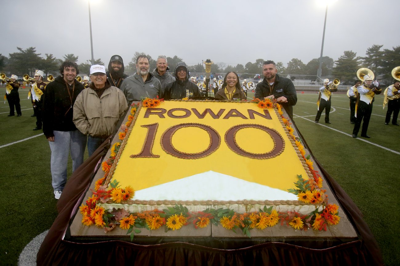 With the torch safely delivered, the team joined with Athletic Director John Giannini (fourth from right) and Alumni Association President Jon J. Vogel (right) to celebrate with a giant Centennial cake.