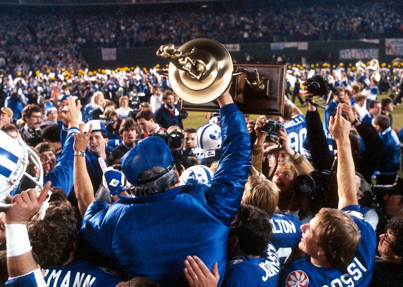 LaVell lifting the trophy after winning the 1984 Holiday Bowl.
