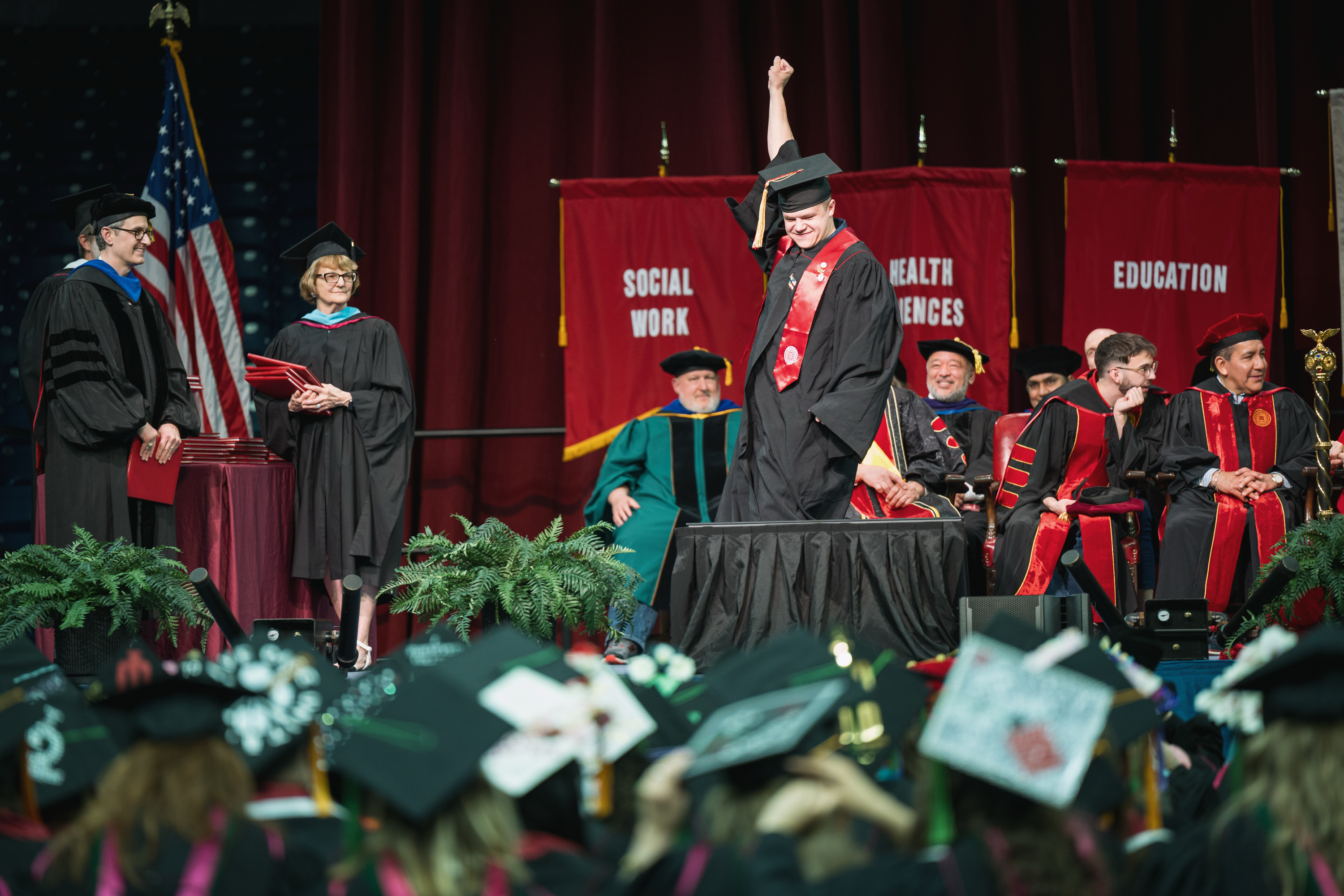 A graduate celebrates as he walks across the stage during the IU South ...