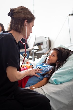 Pediatrician Judy Blumhoffer checks the heartbeat and breathing of 6-year-old Sherly Valentina.