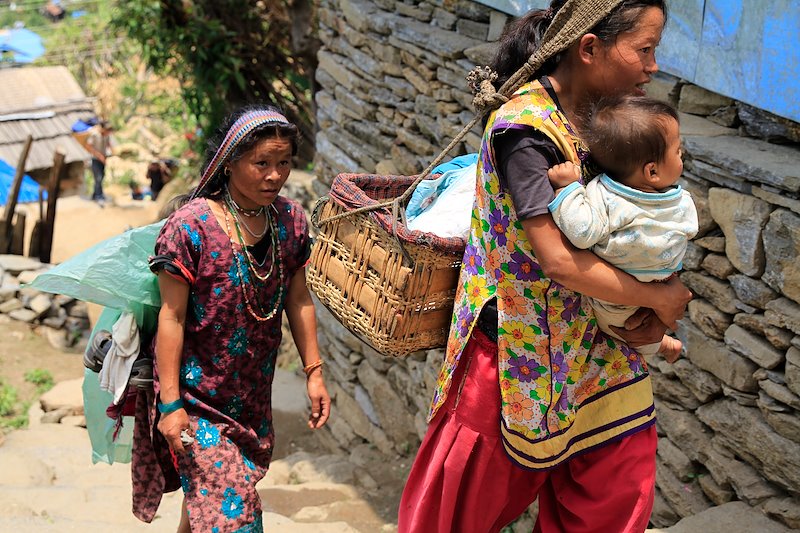 A mother carries her young child in her arms, while the traditional 'kokro' basket is at the ready for naptime.