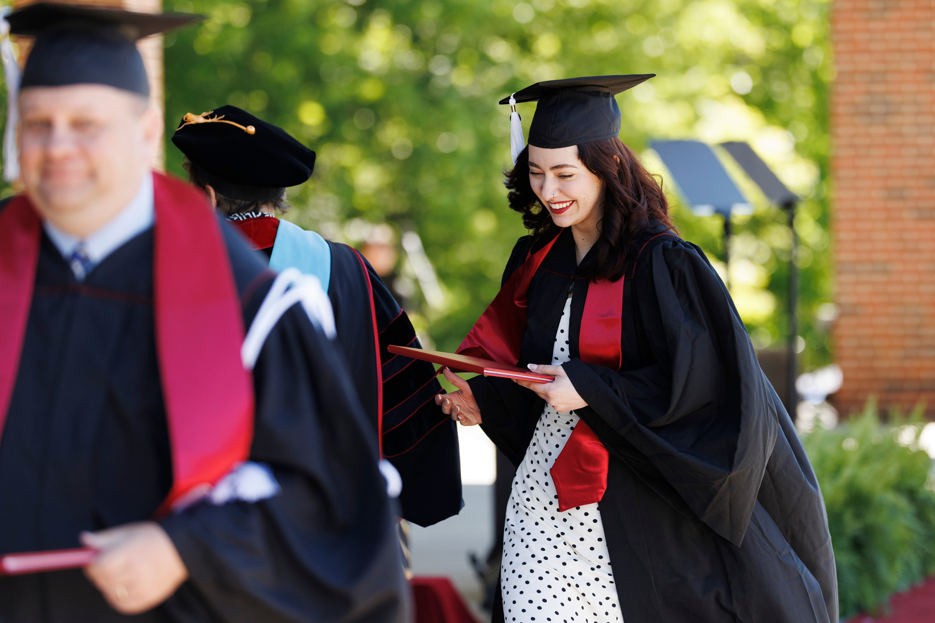 A graduate receives her diploma cover during the IU Southeast ...
