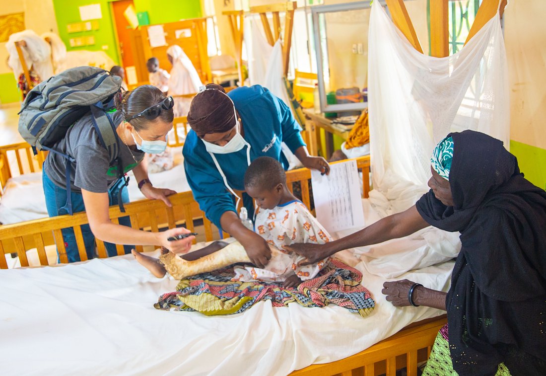 Dr Shelley( left), Haoua (in the middle) and Simon's grandmother are showering Simon with their care and love. Simon will soon go to the OR confidently, knowing that Everyone focused on his healing.