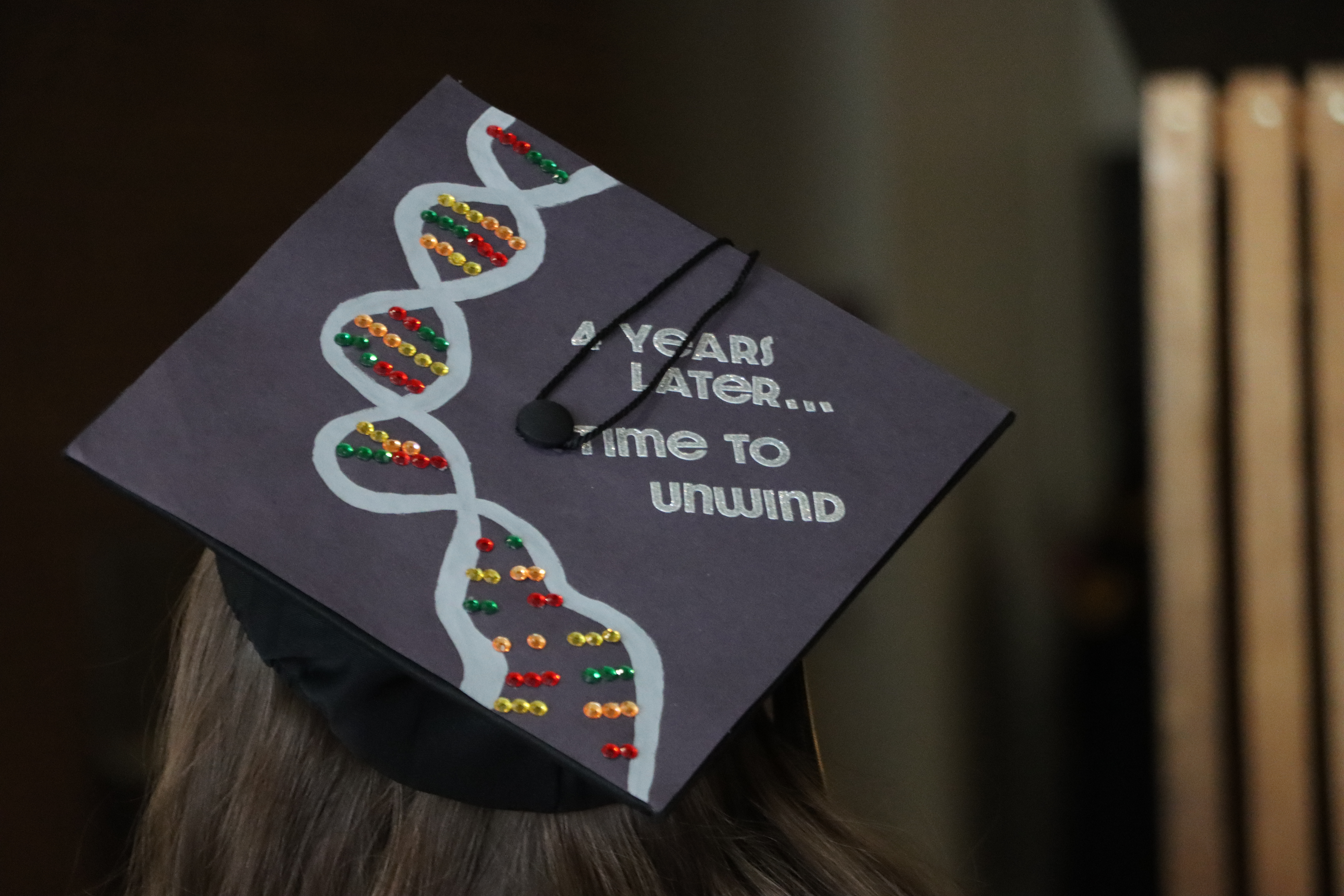 A graduation cap is decorated with a DNA strand and says, 4 years later ...