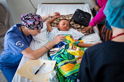 Bethany Densham , cleft lip and palate program advisor, prays for  Antony before he receives life-changing  surgery.