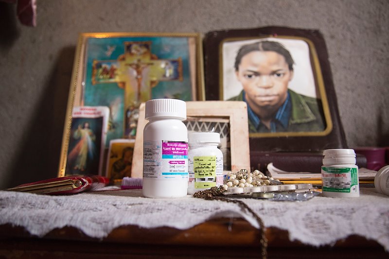 Sarah’s medication sits next to a portrait of her late brother Peter, who helped her accept her HIV status.