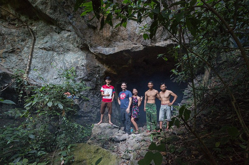 Us and our Vietnamese trekking crew posing outside of the weapons cave.