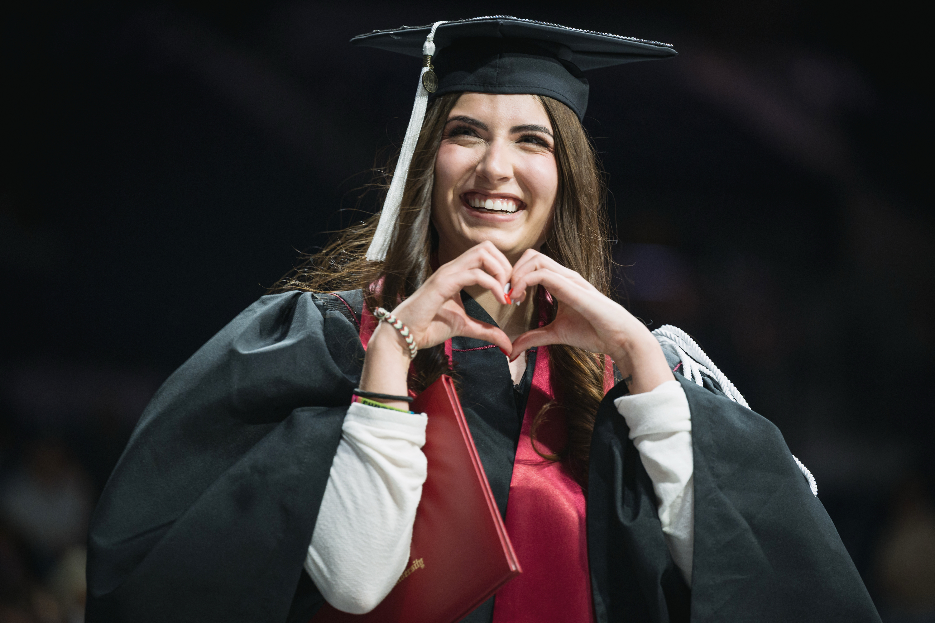 A graduate signals a heart to the audience during the IU South Bend ...