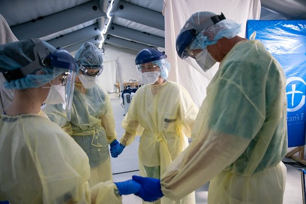 Staff pray during their shift in a general care ward in Cremona.