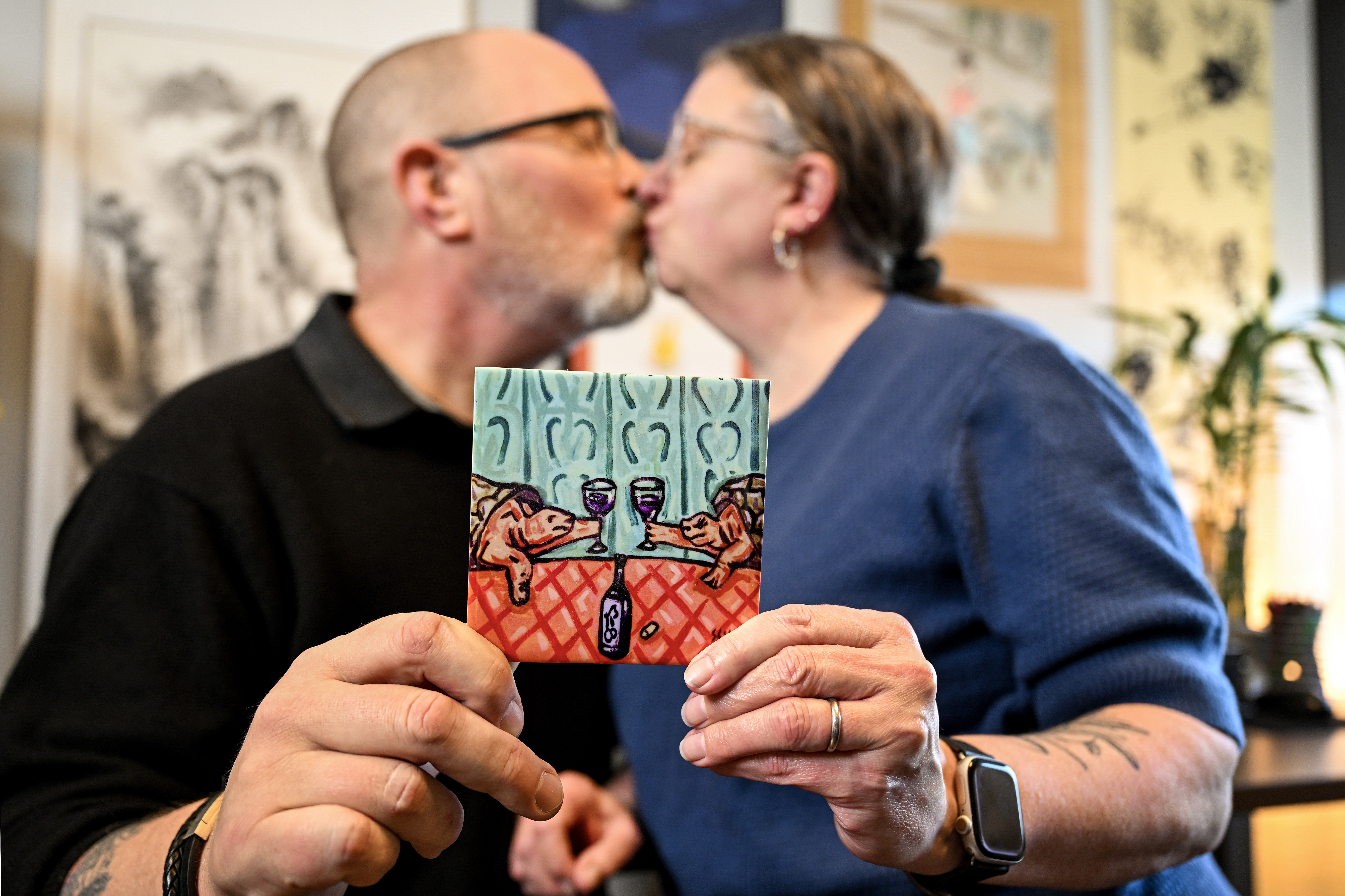 WVU couple Alex Snow and Alyssa Beall share a quick kiss as they hold a ...