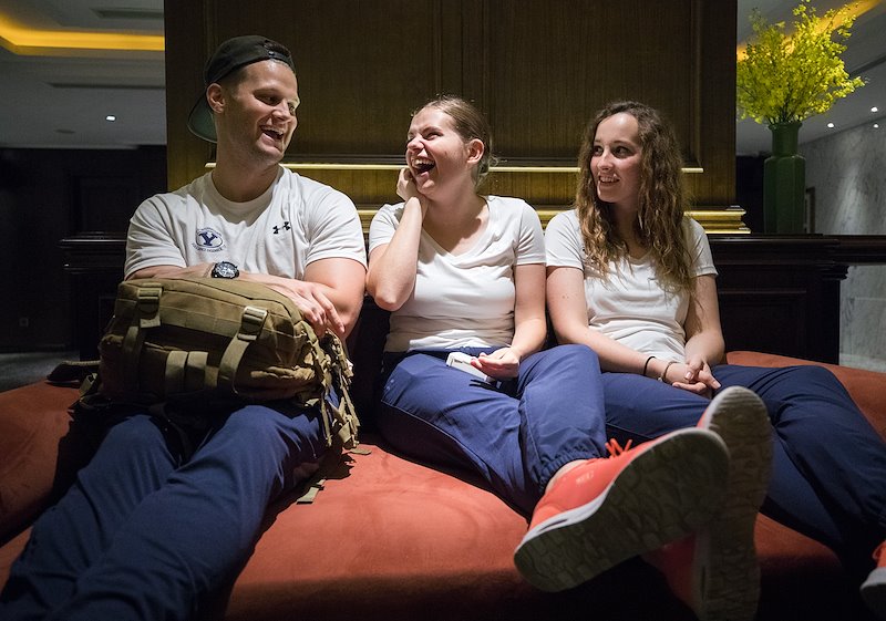 Jordan Ringer, Carissa Moser and Aubrey Nielson tell stories of their day before a team meeting. Photo by Jaren Wilkey/BYU