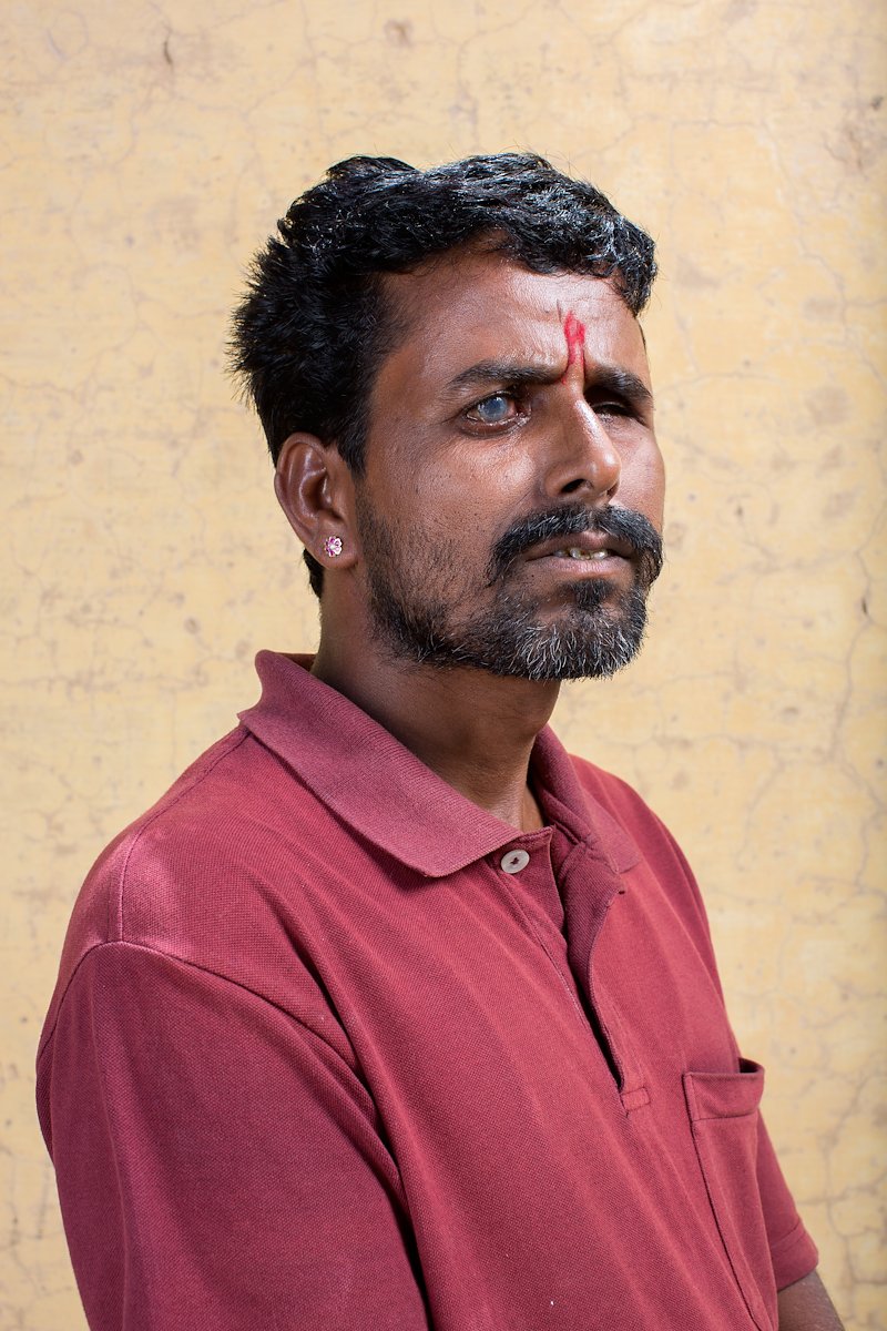 Portrait photograph of 36 year old Shyam Sundar. His left eye is closed, while his right has a glazed appearance.
