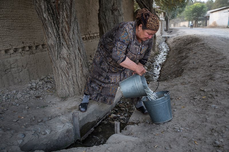 Anabar Nosirova, who works in the school's kitchen, gathers water from a nearby aryk.