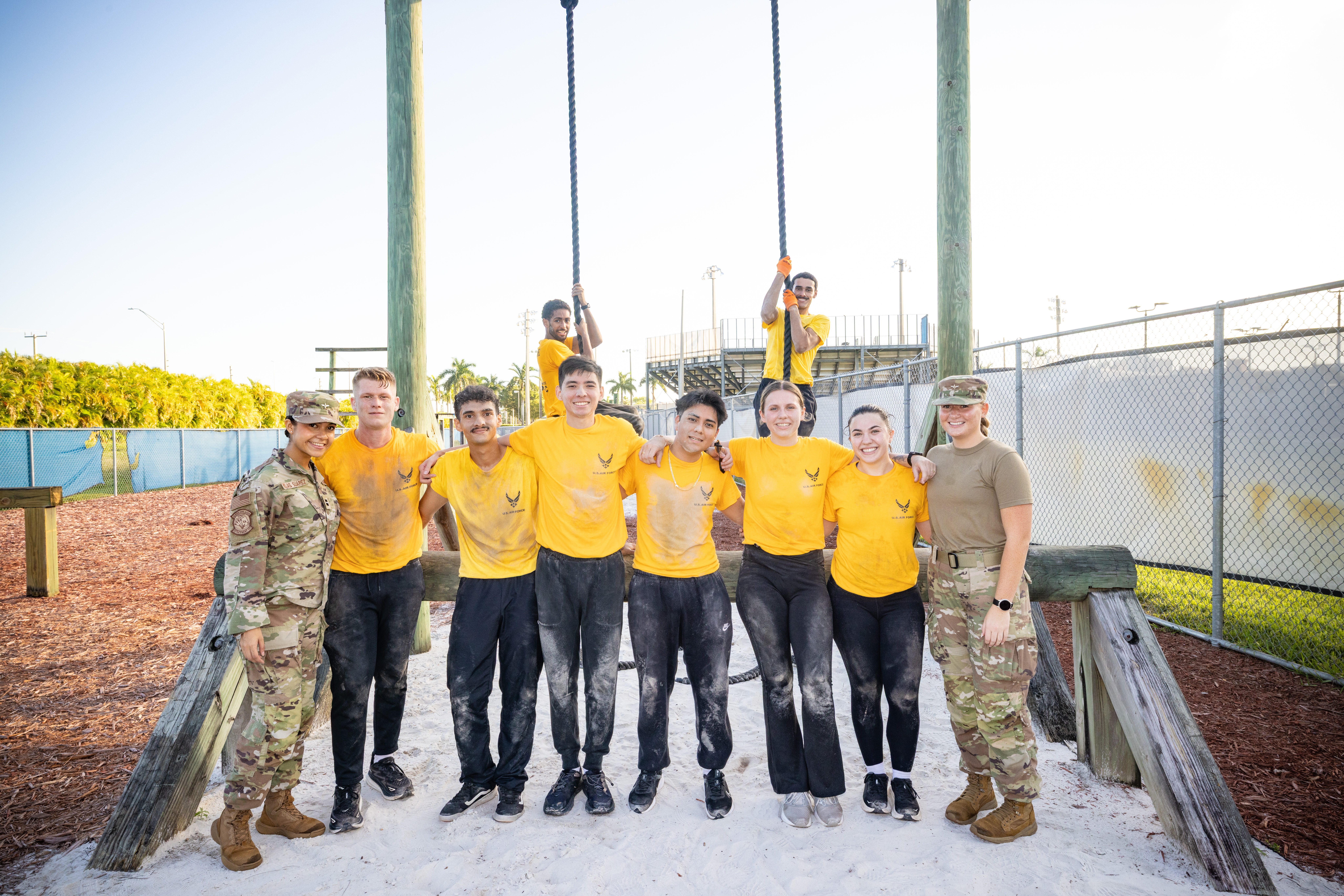 A group of Air Force cadets and leaders pose on an obstacle course. The ...