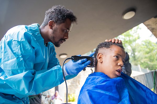 Temesgen, from the spiritual department, cuts Kasib's hair, a CURE patient.