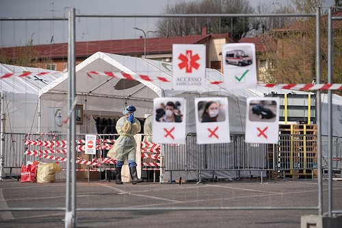 A staff member performs a final mask check as she enters the hot zone in front of the ambulance entrance to the SP field hospital in Cremona, Italy.