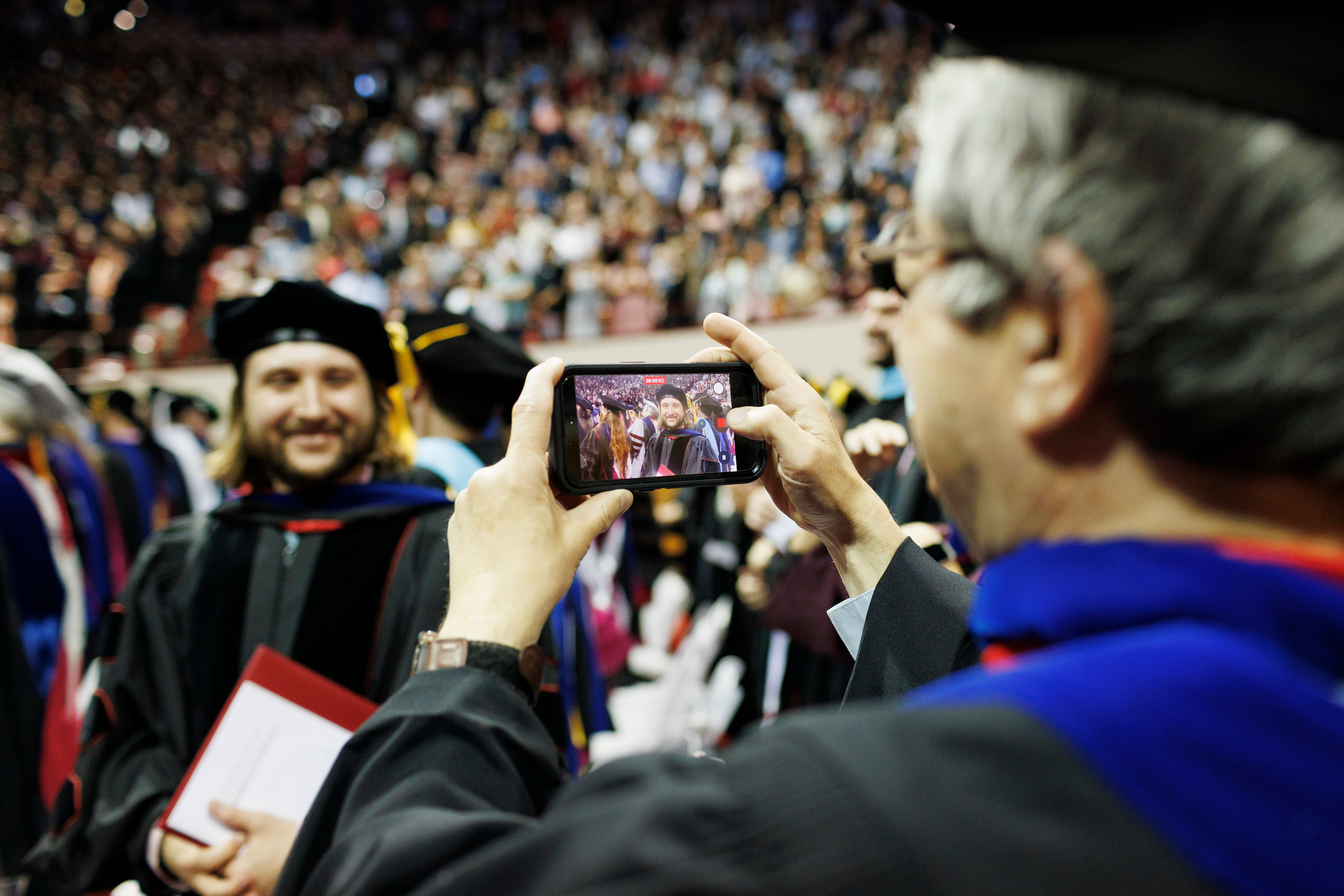 A graduate poses for a cell phone photo during the IU Bloomington ...