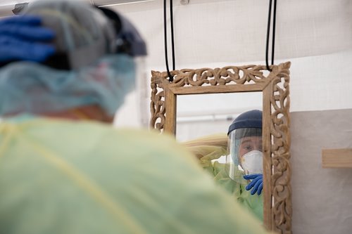 Stephen, a medical information officer, checks his PPE before entering the hot zone.