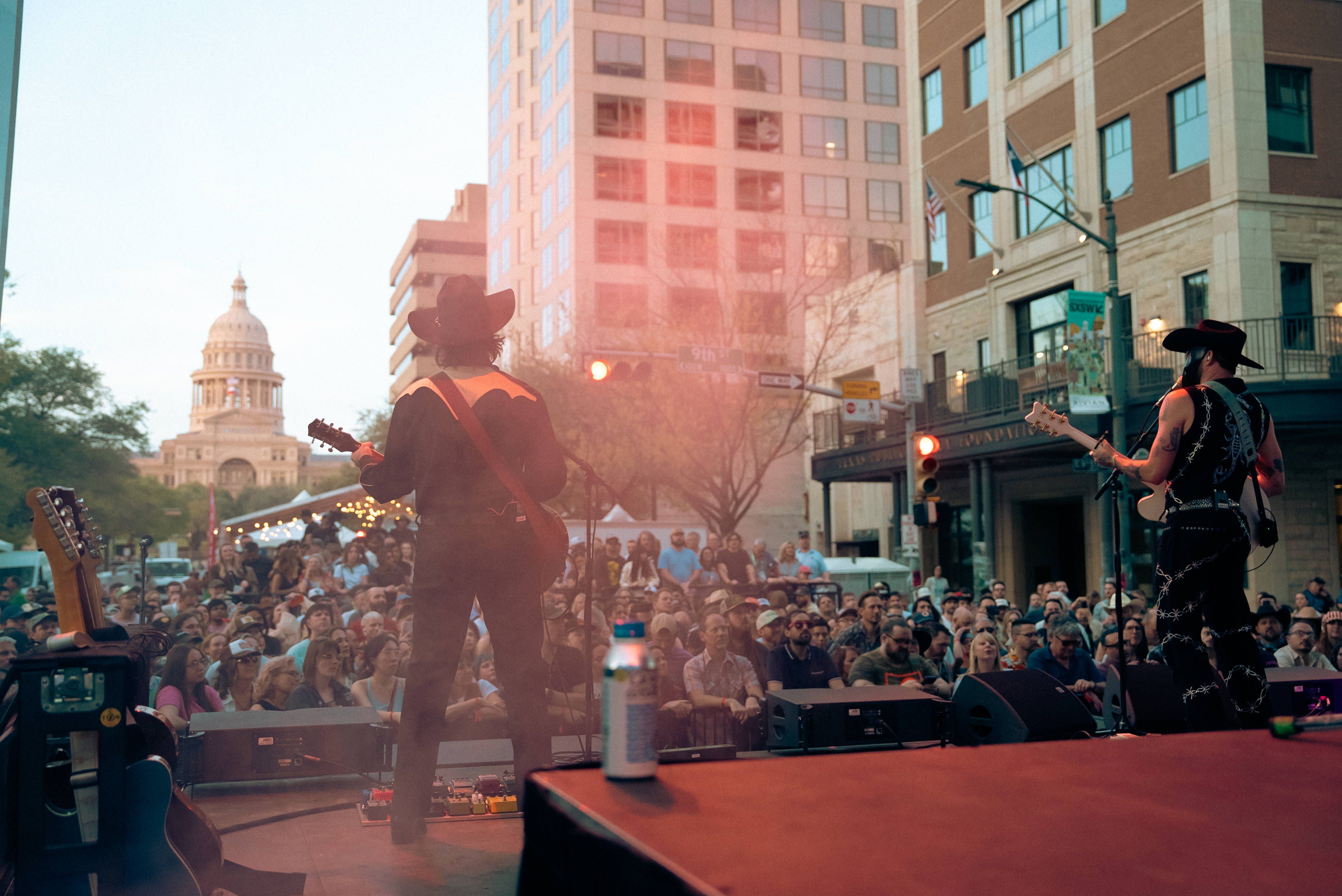 Two musicians perform on an outdoor stage for a large crowd at SXSW ...