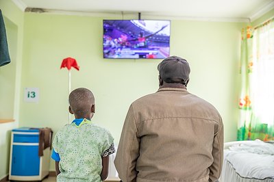 A father and his daughter watching a previous historical moment in the olympics.