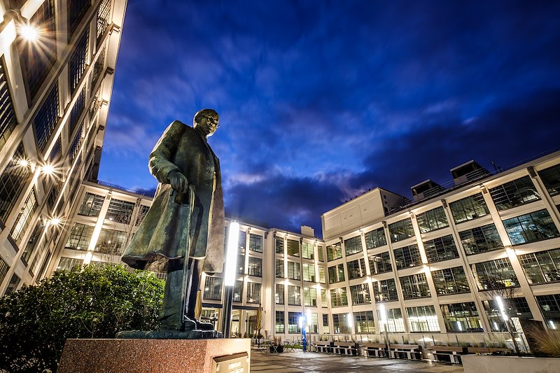 The statue of Bowman Gray stands sentinel over the courtyard of Wake Downtown at dusk.