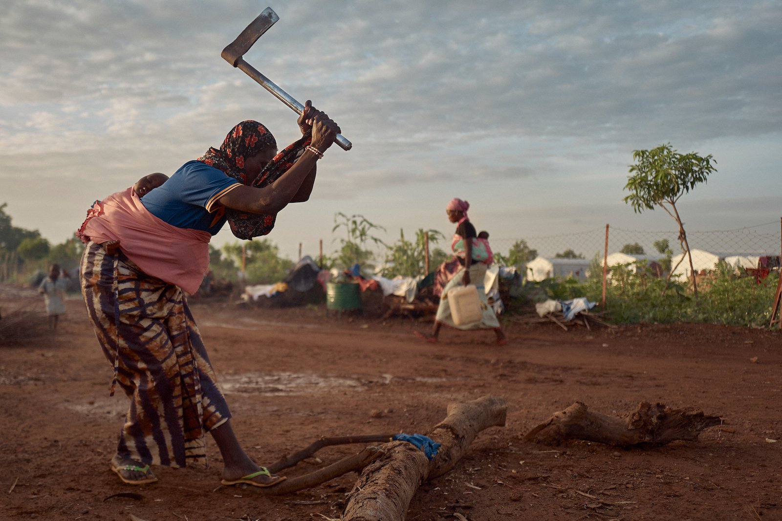 A woman cuts firewood in Tiwega 1, a camp for displaced people in Kaya, in Burkina Faso's Centre-Nord Region. Credit: UNOCHA/Michele Cattani