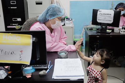 Social worker Mona gives CUREkid Andrea a hi-five for being such a good sport throughout her healing journey.