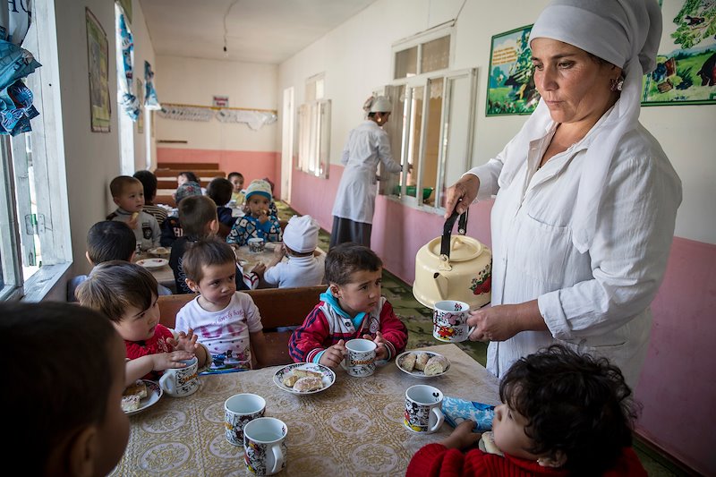 Kindergarten worker Turdenisa Khydyraieva provides boiled water and cookies to children.