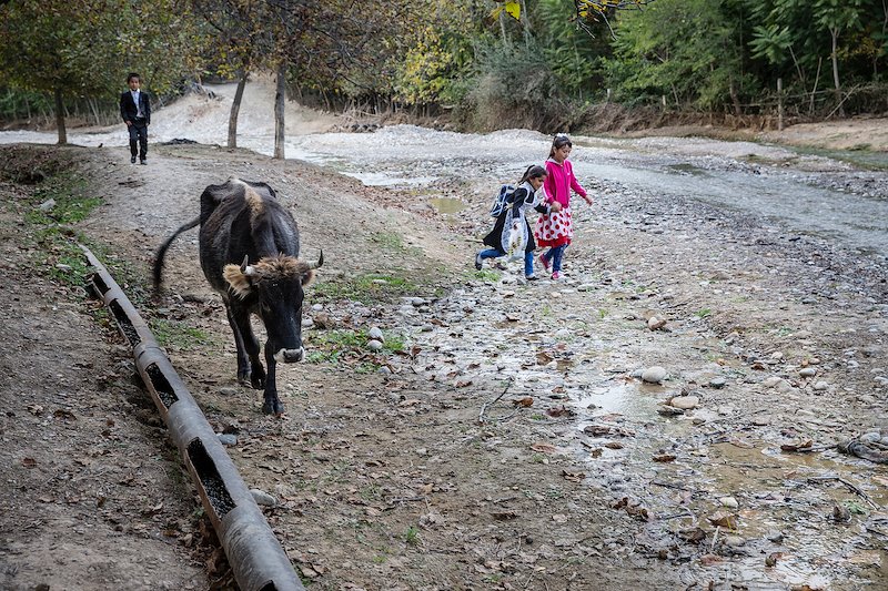 Children returning from school have to cross a river which is also the source of household water.