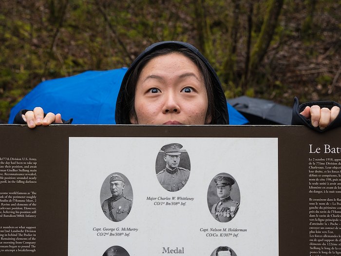 A student breaks the tension by peeking over the historical marker at the Lost Battalion site.