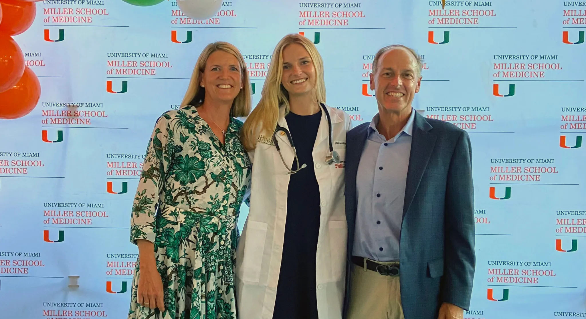 A medical student in a white coat poses with her parents at Match Day ...
