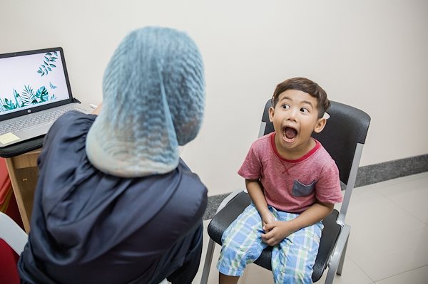 Xian opened his mouth big enough for speech therapist to see his healed palate.