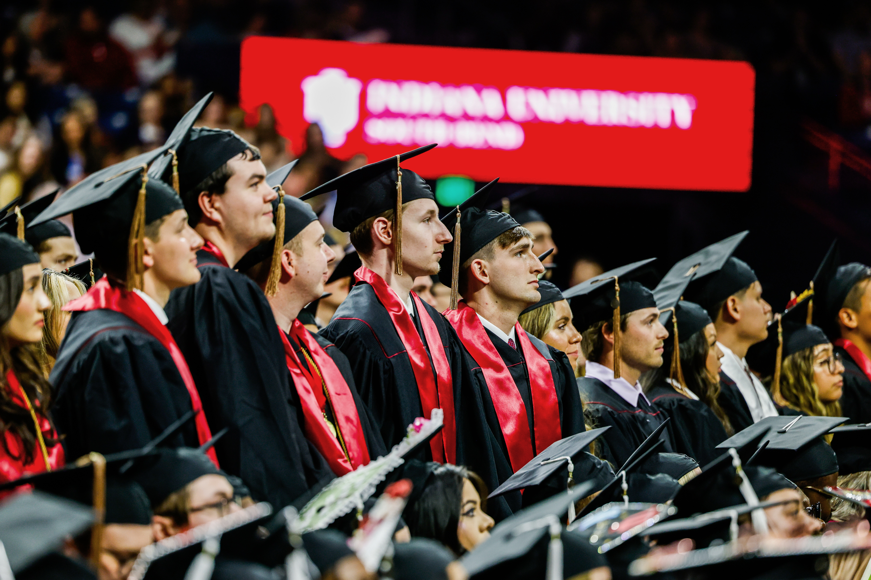 Graduates stand during the conferral of degrees during the IU South ...