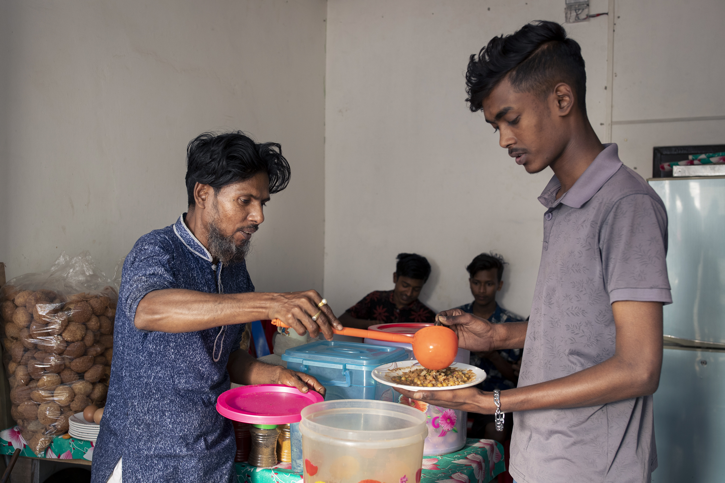 Asad serves chotpoti to a customer.