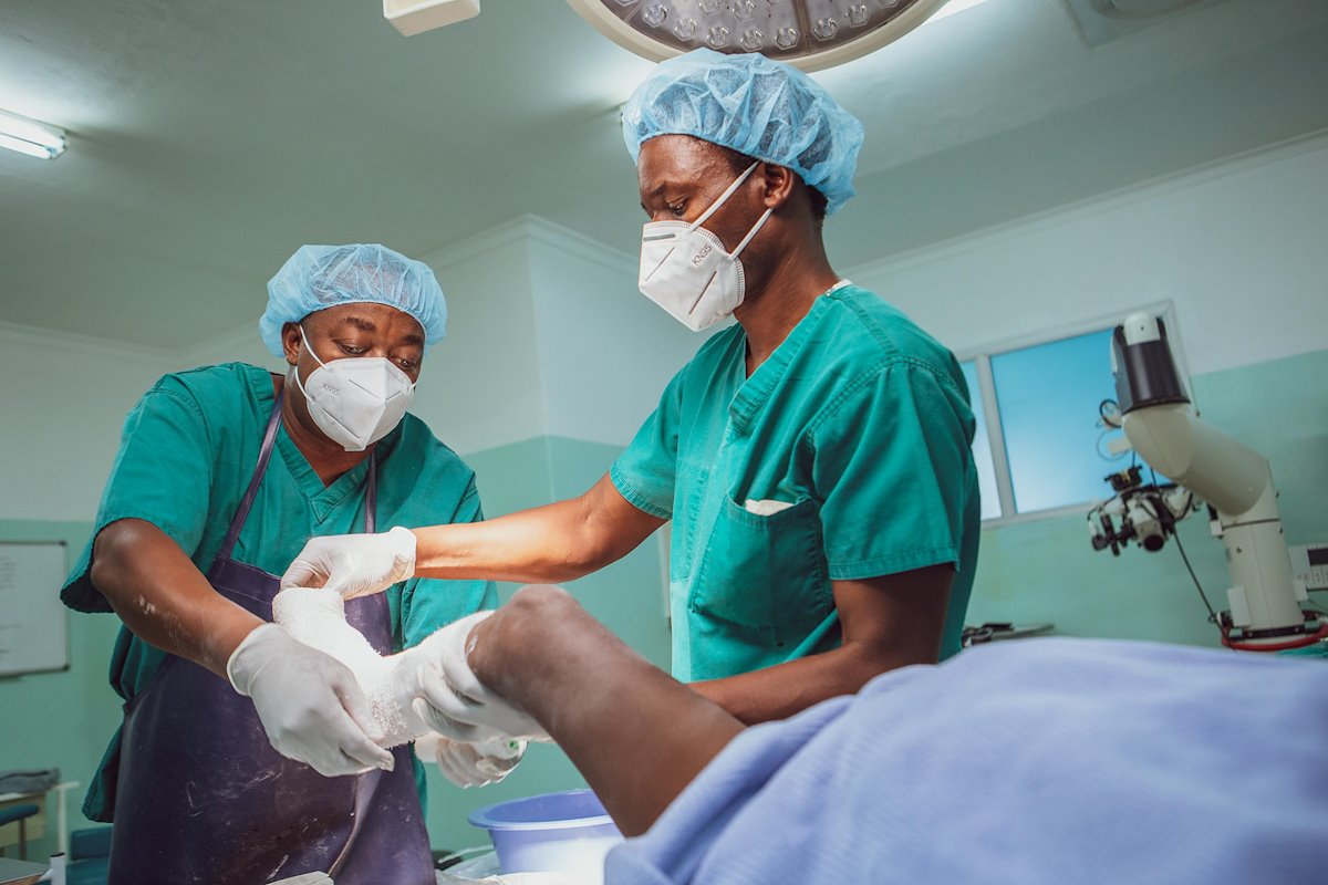 Dr. Maweja and Luka completing a dressing change in the operating room.