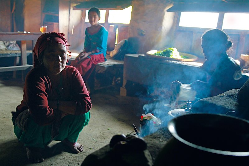 Women tend the fire and make tea in a traditional home