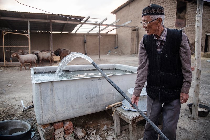 A shepherd fills a water tank he uses for his animals.