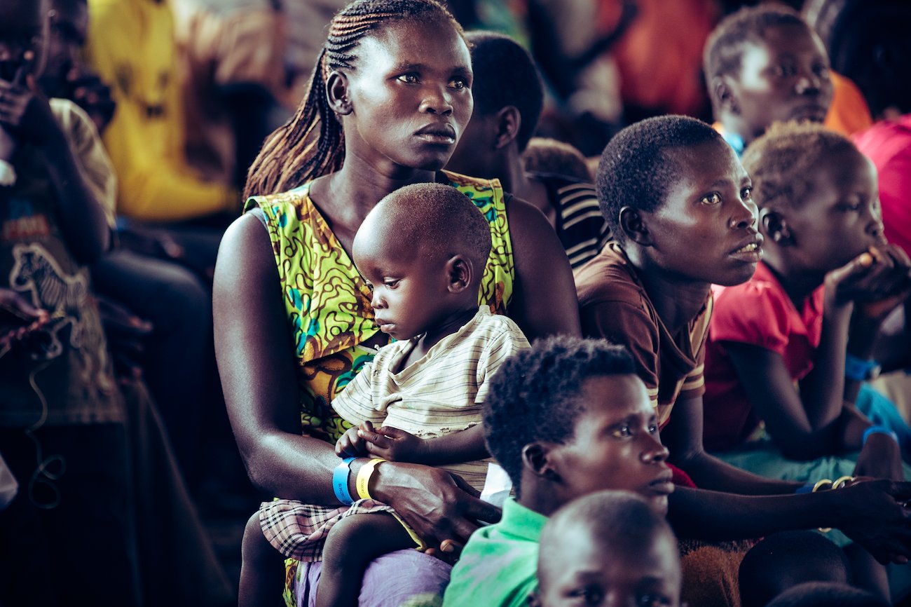 A mother and her child wait patiently in one of the processing areas for their name to be called.