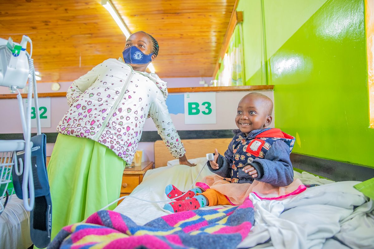 Fridah smiling at a nurse because he didn't inflict any pain during a vitals round.