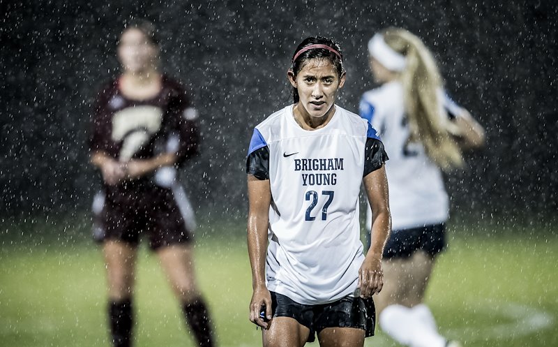 Elena Medeiros competes against Denver's soccer team in a rain storm - Photo by Nate Edwards/BYU
