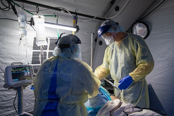 Dr. Mark, right, checks in on an ICU patient.