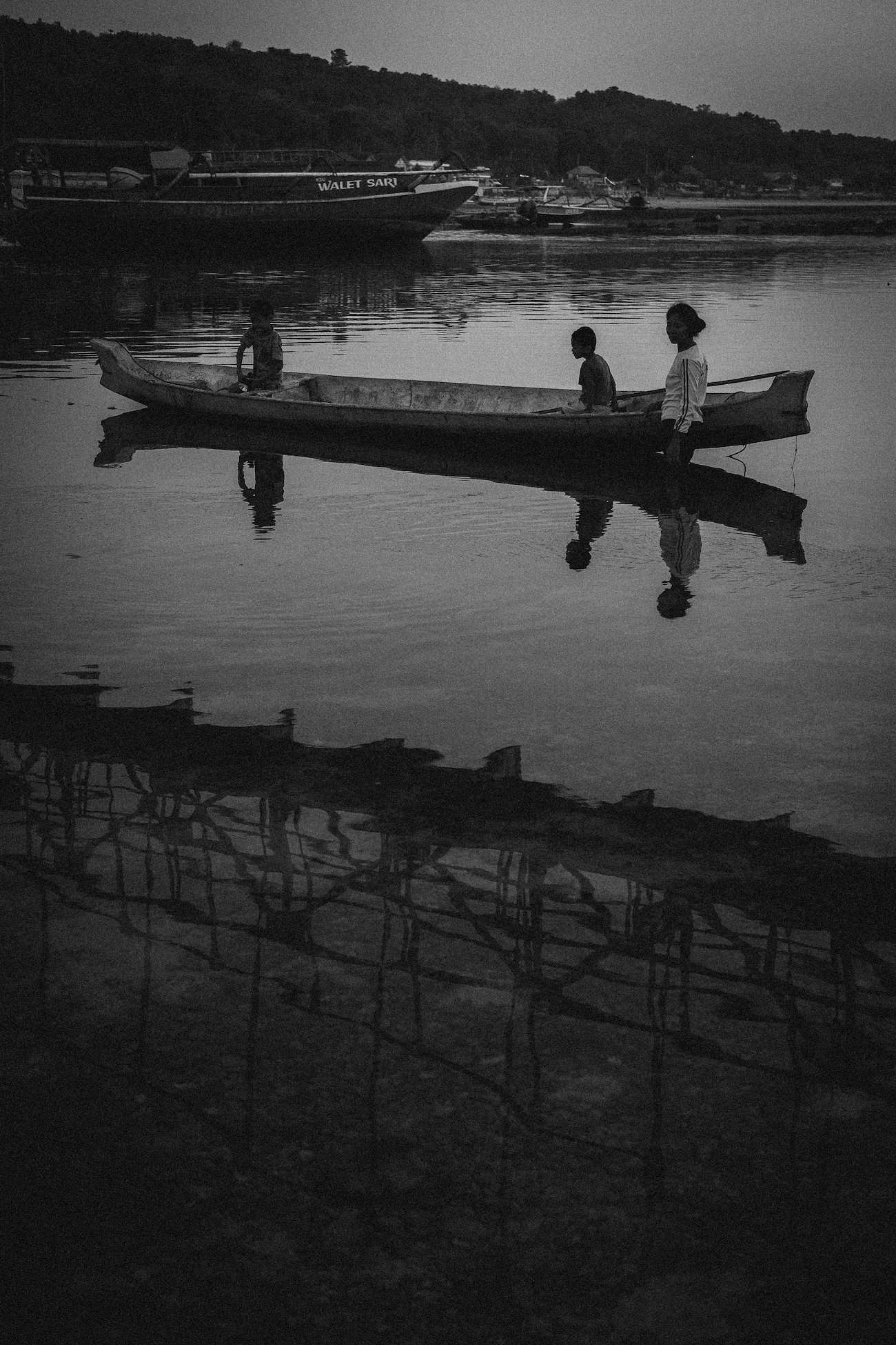 Mother and her children are crossing the river under the Yellow Bridge in Nusa Penida