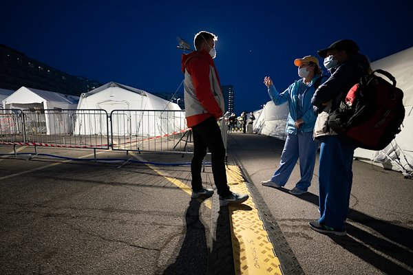 Day shift staff, right, discuss patient care details with the night shift staff during shift change.